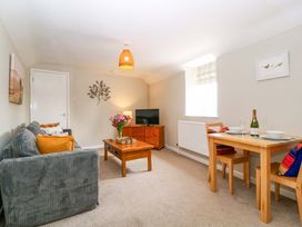 A living room with a sofa, coffee table and dining area at Farm View Annex in Painswick