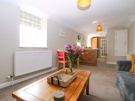 A living room with a table and flowers at Farm View Annex in Painswick