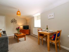 A living room with a sofa, coffee table, and television at Farm View Annex in Painswick