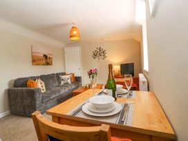 A living room with a sofa, table, and television at Farm View Annex in Painswick
