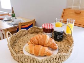 A kitchen with croissants, jam jars and orange juice at Farm View Annex, Painswick