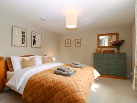 A bedroom with a bed, dresser, and wall art at Farm View Annex in Painswick