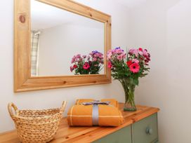 A dresser with flowers and a basket at Farm View Annex, Painswick