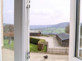 A view from a window showing a dog and buildings at Farm View Annex in Painswick
