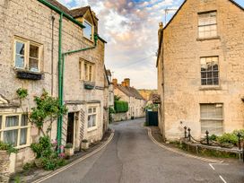 A street with stone buildings and flowers at Farm View Annex in Painswick