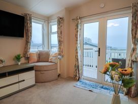 A living room with a television and seating area at Gorse Hill 211 in Exmouth