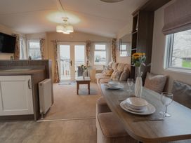 A living room with a sofa and dining table at Gorse Hill 211 in Exmouth