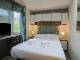 A bedroom with a bed and television at Gorse Hill 211 in Exmouth