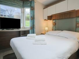 A bedroom with a bed and television at Gorse Hill 211 Exmouth