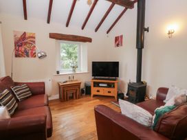 A living room with a television and wood stove at The Spinney near Milnthorpe