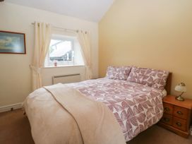 A bedroom with a bed and window at The Spinney near Milnthorpe