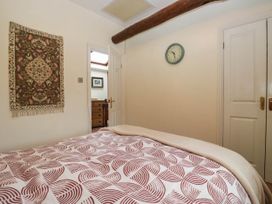 A bedroom with a bed and wall clock at The Spinney near Milnthorpe