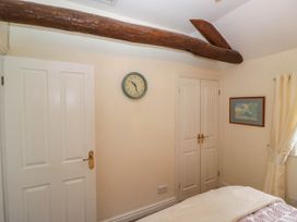 A bedroom with a clock and doors in The Spinney near Milnthorpe