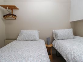 A bedroom with two beds and a lamp at The Spinney near Milnthorpe