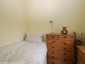 A bedroom with a bed and furniture at The Spinney near Milnthorpe