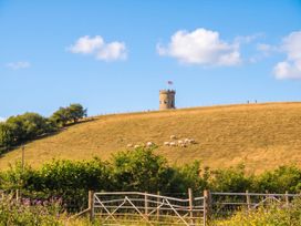 A landscape featuring a tower on a hill with sheep grazing at The Spinney near Milnthorpe