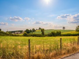 A field with trees and a house in the background at The Spinney near Milnthorpe