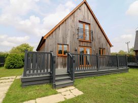 A house with a deck and railing at James Ville Marina Lodge 8 Brigg