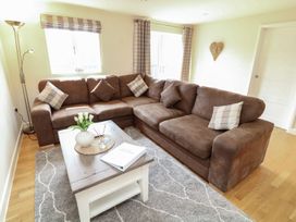 A living room with a brown sofa and coffee table at James Ville Marina Lodge 8 in Brigg