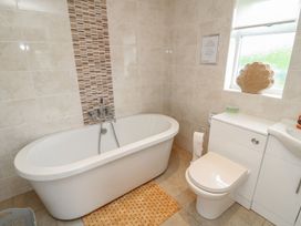 A bathroom with a bathtub, toilet, and sink at James Ville Marina Lodge 8 in Brigg