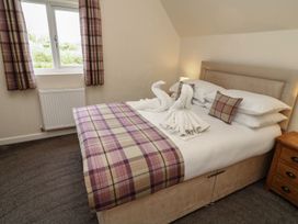 A bedroom with a bed and towels arranged in a swan shape at James Ville Marina Lodge 8 in Brigg