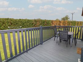 A deck with a table and chairs at James Ville Marina Lodge 8 in Brigg