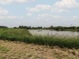 A landscape with a river and grassy area at James Ville Marina Lodge 8 in Brigg