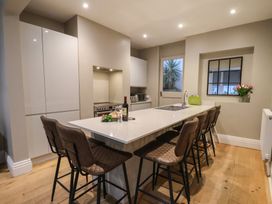 A kitchen with modern cabinets and bar stools at South Villa Sandsend near Whitby