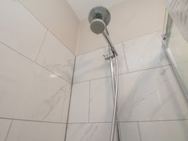 A showerhead and wall tiles at South Villa in Sandsend near Whitby