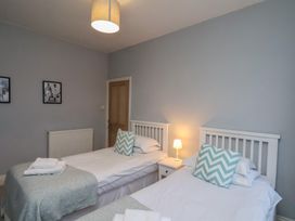A bedroom with two beds and a lamp at South Villa in Sandsend near Whitby