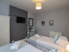 A bedroom with two beds and a television at South Villa Sandsend near Whitby