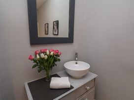 A bathroom with a sink and flowers at South Villa Sandsend near Whitby
