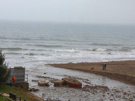 A beach with a sea and a boat at South Villa Sandsend near Whitby