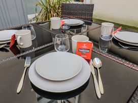 A dining table set with plates, mugs, glasses, cutlery, and Yorkshire Tea at South Villa Sandsend near Whitby