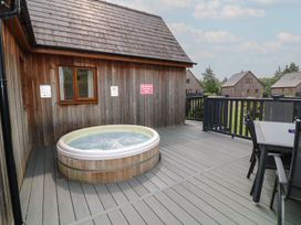 A hot tub on a deck next to a wooden cabin at James Ville Marina Lodge 9 in Brigg