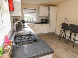 A kitchen with a sink, counter and stools at James Ville Marina Lodge 13 in Brigg