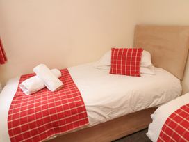 A bedroom with a single bed and towels at James Ville Marina Lodge 13 in Brigg