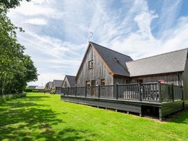 A house with a deck and grass area at James Ville Marina Lodge 13 in Brigg