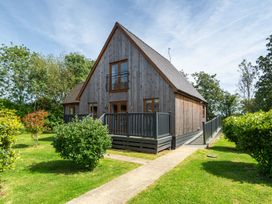 A house with a balcony in a garden at James Ville Marina Lodge 13, Brigg