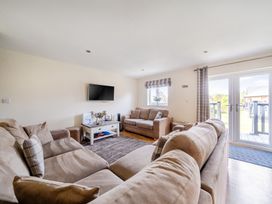 A living room with a television and a sofa at James Ville Marina Lodge 13 in Brigg