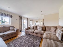A living room with a sofa and a table at James Ville Marina Lodge 13 in Brigg