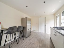 A kitchen with bar stools and a refrigerator at James Ville Marina Lodge 13 in Brigg