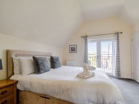 A bedroom with a large bed and a balcony door at James Ville Marina Lodge 13 in Brigg