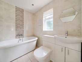 A bathroom with a bathtub, toilet, sink and mirror at James Ville Marina Lodge 13 in Brigg