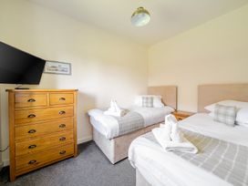 A bedroom with two beds and a dresser at James Ville Marina Lodge 13 in Brigg