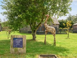 A giraffe sculpture and sign in front of lodges at James Ville Marina Lodge 13 in Brigg