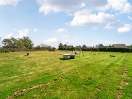 A garden with swings and a picnic table at James Ville Marina Lodge 13 in Brigg