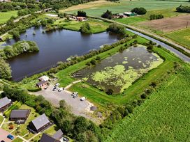 An aerial view of a pond with surrounding greenery and vehicles at James Ville Marina Lodge 13 in Brigg