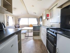 A kitchen with a table and chairs at Dunes View in Prestatyn