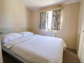 A bedroom with a bed and curtains at Dunes View in Prestatyn